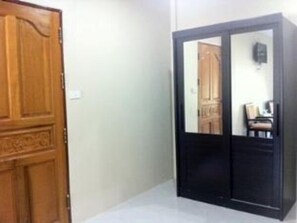A room with a wooden door and a black wardrobe with a mirror. - Win Resort Hat Yai (Hat Yai)