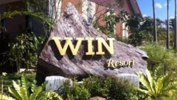 A large wooden sign with the text "WIN Resort" in front of a building surrounded by lush greenery. - Win Resort Hat Yai (Hat Yai)