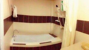 A bathroom with a bathtub, a shower, and a toilet. - Win Resort Hat Yai (Hat Yai)