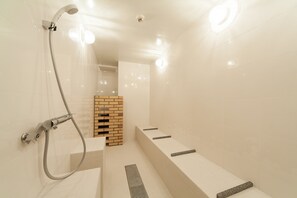A modern bathroom with a shower, a toilet, and a sink.