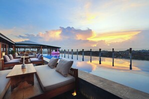 Een buitenzwembad, ligstoelen bij het zwembad