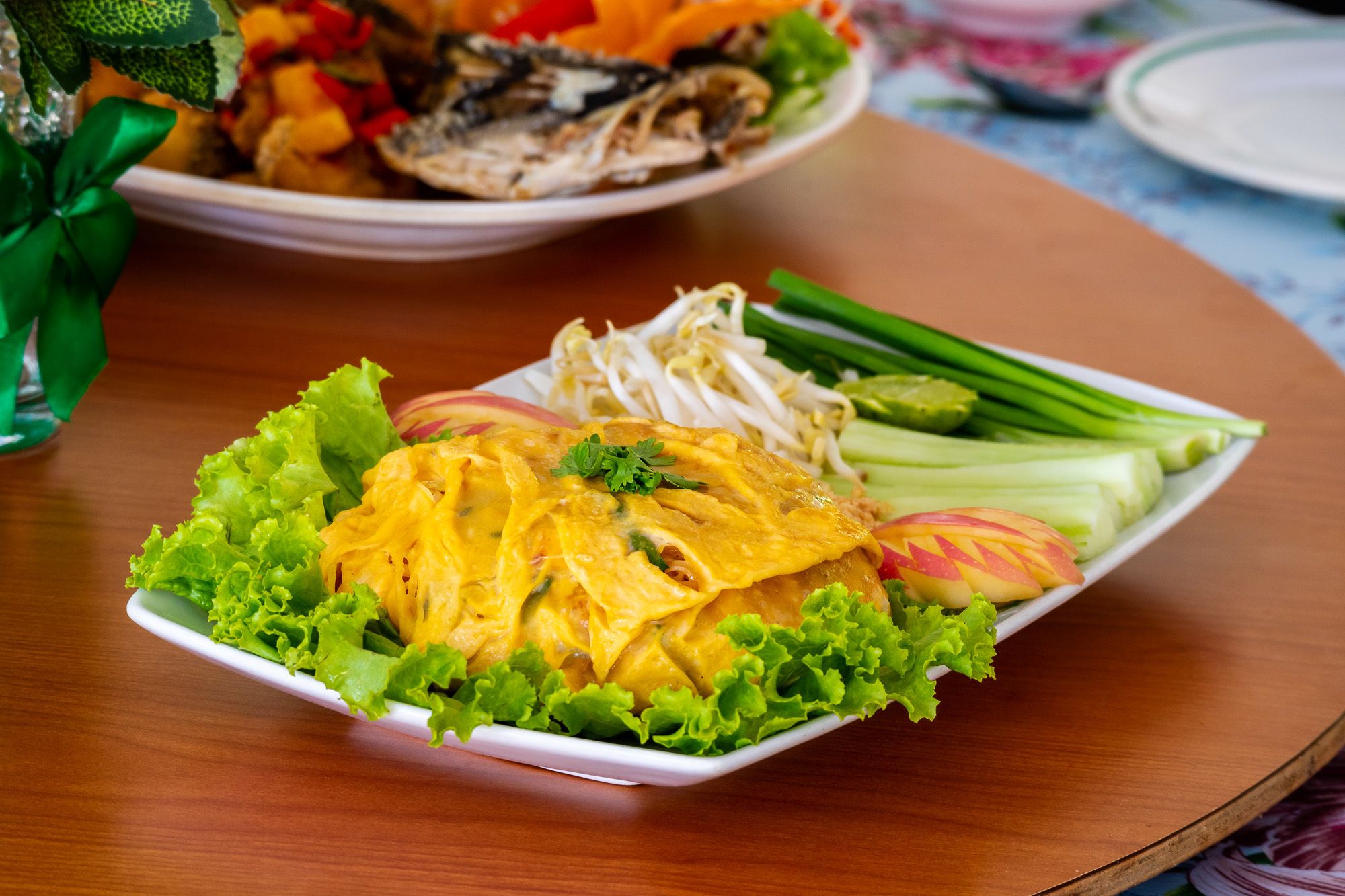 A plate of food with lettuce, sliced apples, and green onions.