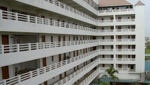 A multi-story hotel with balconies, a swimming pool, and outdoor plants. - Hatyai Paradise Hotel (Hat Yai)