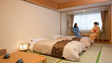 A traditional Japanese room with tatami flooring, two beds with shoji screens, a wooden table with tea sets, and a window with curtains.