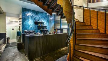 Eine moderne Bar mit einer Holztreppe und einer blauen, strukturierten Wand.