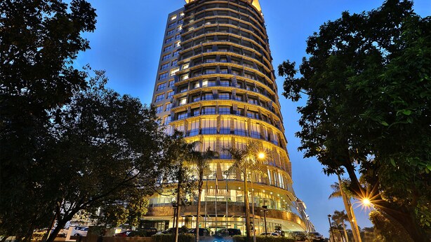 Un grand hôtel moderne à la façade incurvée et aux fenêtres illuminées.