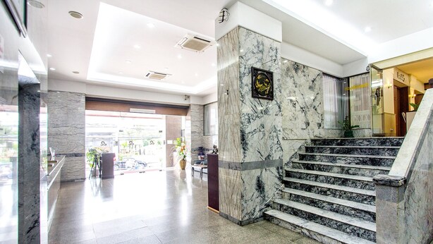 A marble staircase in a modern lobby with a glass entrance and a framed artwork on the wall. - Hat Yai Rama Hotel (Hat Yai)