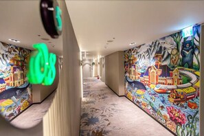 A hotel corridor with vibrant murals on the walls depicting various scenes and characters. - The Cloud Hotel Taichung (Taichung)
