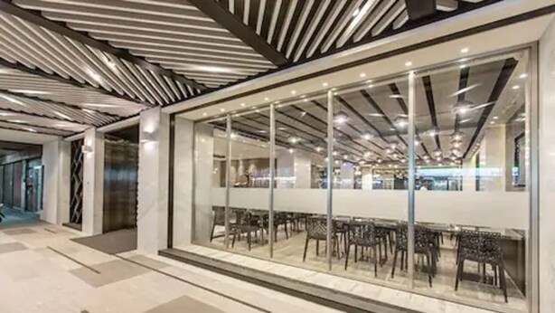 A modern interior with a glass wall, metal ceiling, and rows of chairs. - The Cloud Hotel Taichung (Taichung)