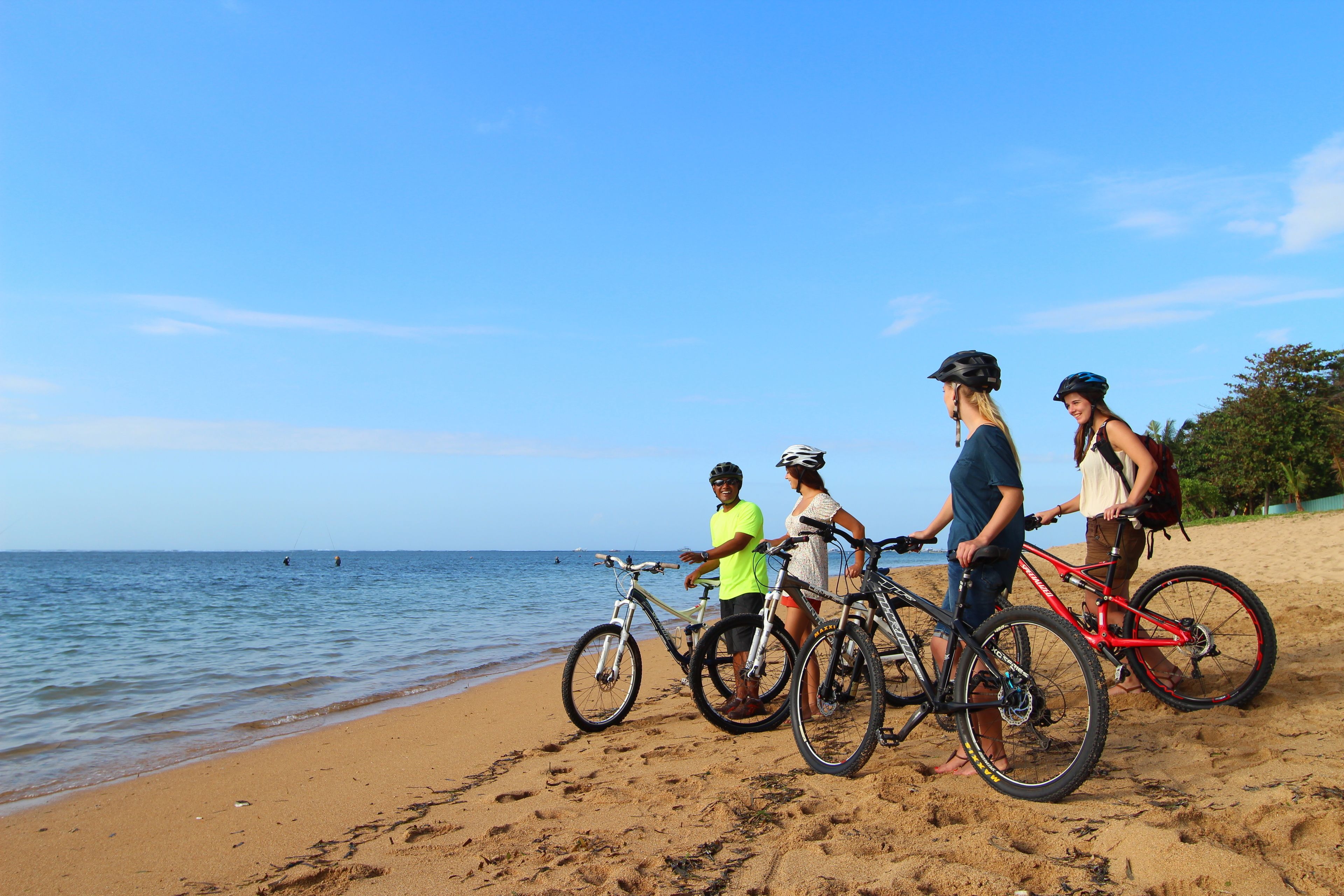 Una playa con bicicletas y gente.
