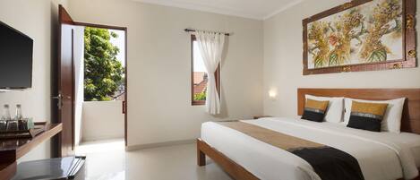 Habitación de hotel con cama, televisión, ventana con cortinas y un cuadro en la pared.