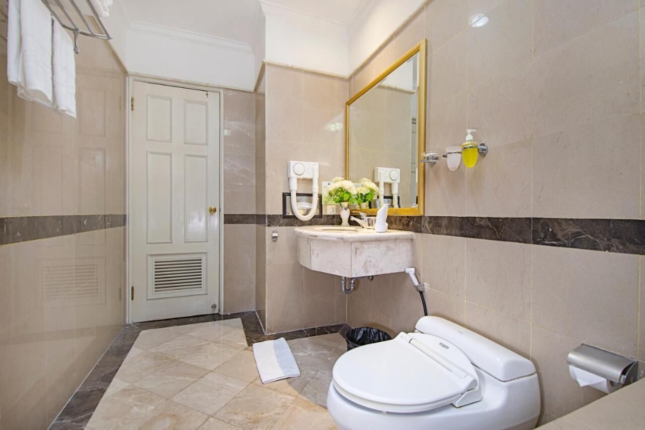 A modern bathroom with a toilet, sink, and mirror.