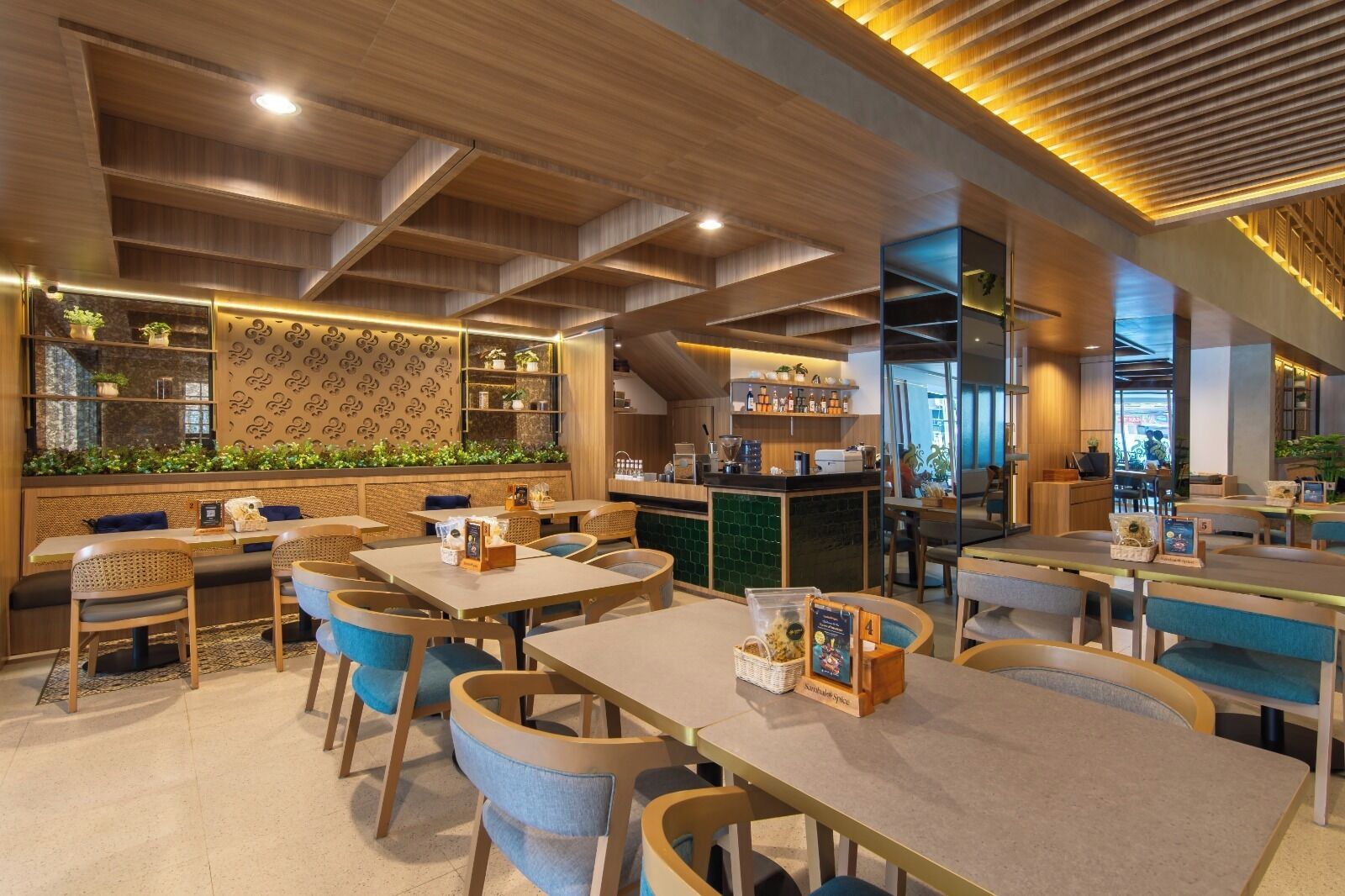 Un restaurante con vigas de madera en el techo, asientos con cojines azules y una zona de bar con estantes.