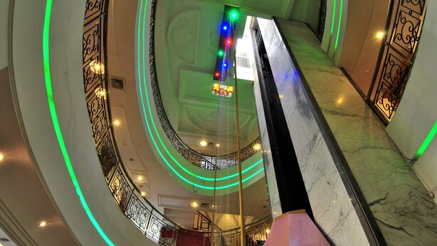 A multi-level interior with a central spiral staircase, decorative railings, and a series of lights along the walls. - Hotel Solitaire Chandigarh (Chandigarh)