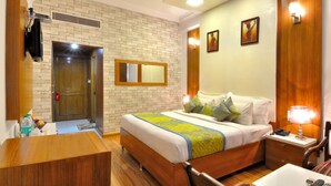 A hotel room with a brick wall, a wooden bed, a bedside table with a lamp, and a bathroom with a sink and mirror. - Hotel Solitaire Chandigarh (Chandigarh)