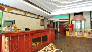 A hotel reception area with a marble floor, a reception desk, a telephone, and a sign indicating the lobby area. - Hotel Solitaire Chandigarh (Chandigarh)