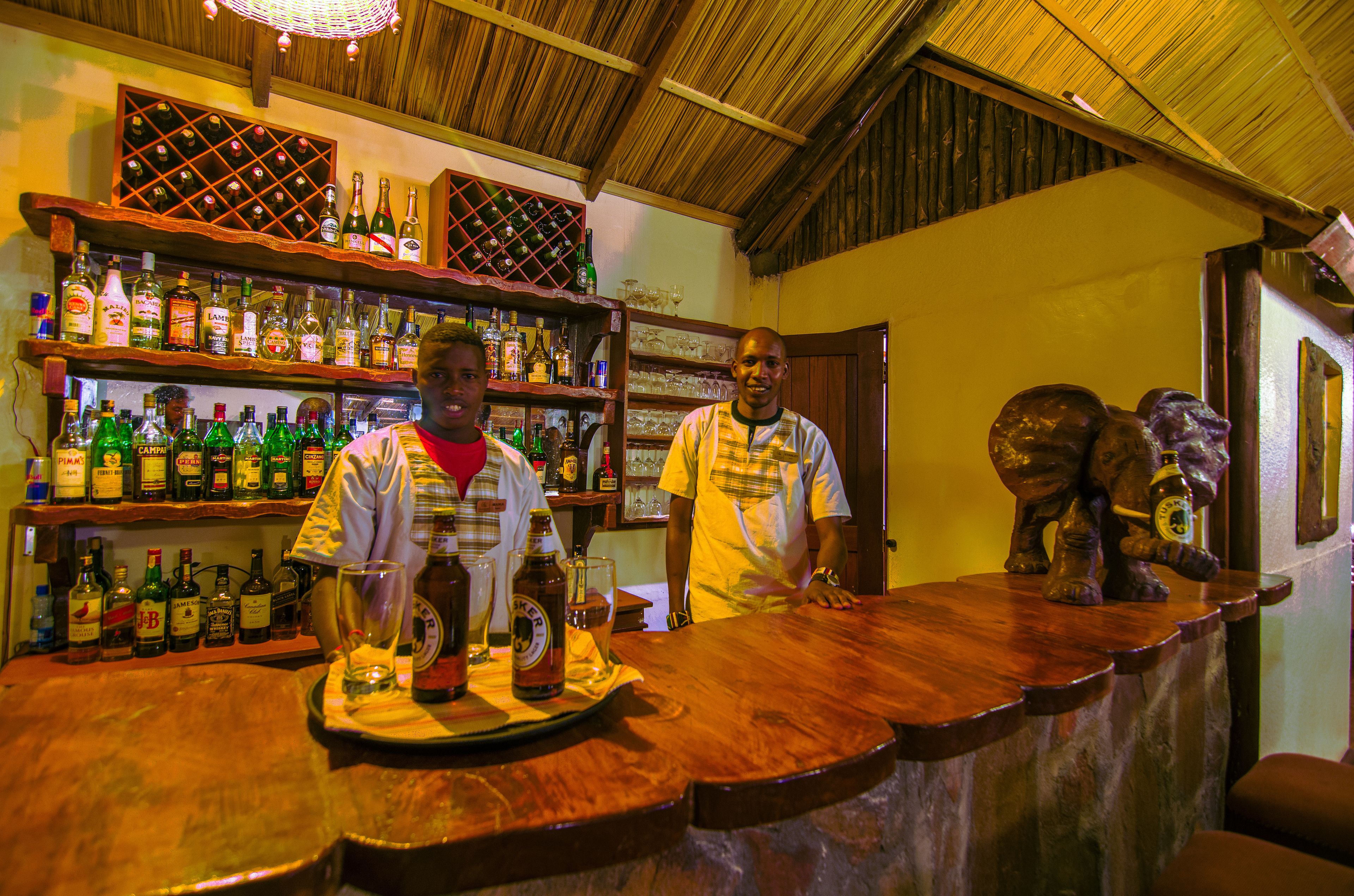 Un bar con estantes de madera llenos de botellas y vasos.