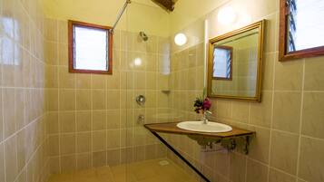 A bathroom with a shower, a sink, and a mirror.