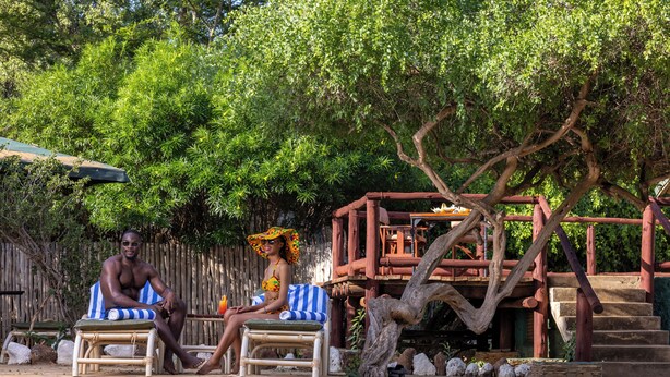 A pool area with lounge chairs and a wooden deck. - Sentrim Tsavo Lodge (Voi)