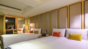 Habitación de hotel con dos camas, un escritorio y un espejo.