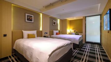 A hotel room with two beds, a large mirror, and a TV.