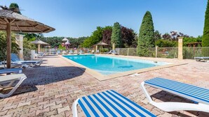A swimming pool area with lounge chairs and a gazebo.