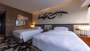 Habitación de hotel con dos camas, una gran obra de arte abstracta en la pared y una alfombra estampada.