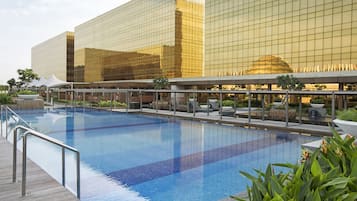 Een buitenzwembad, ligstoelen bij het zwembad