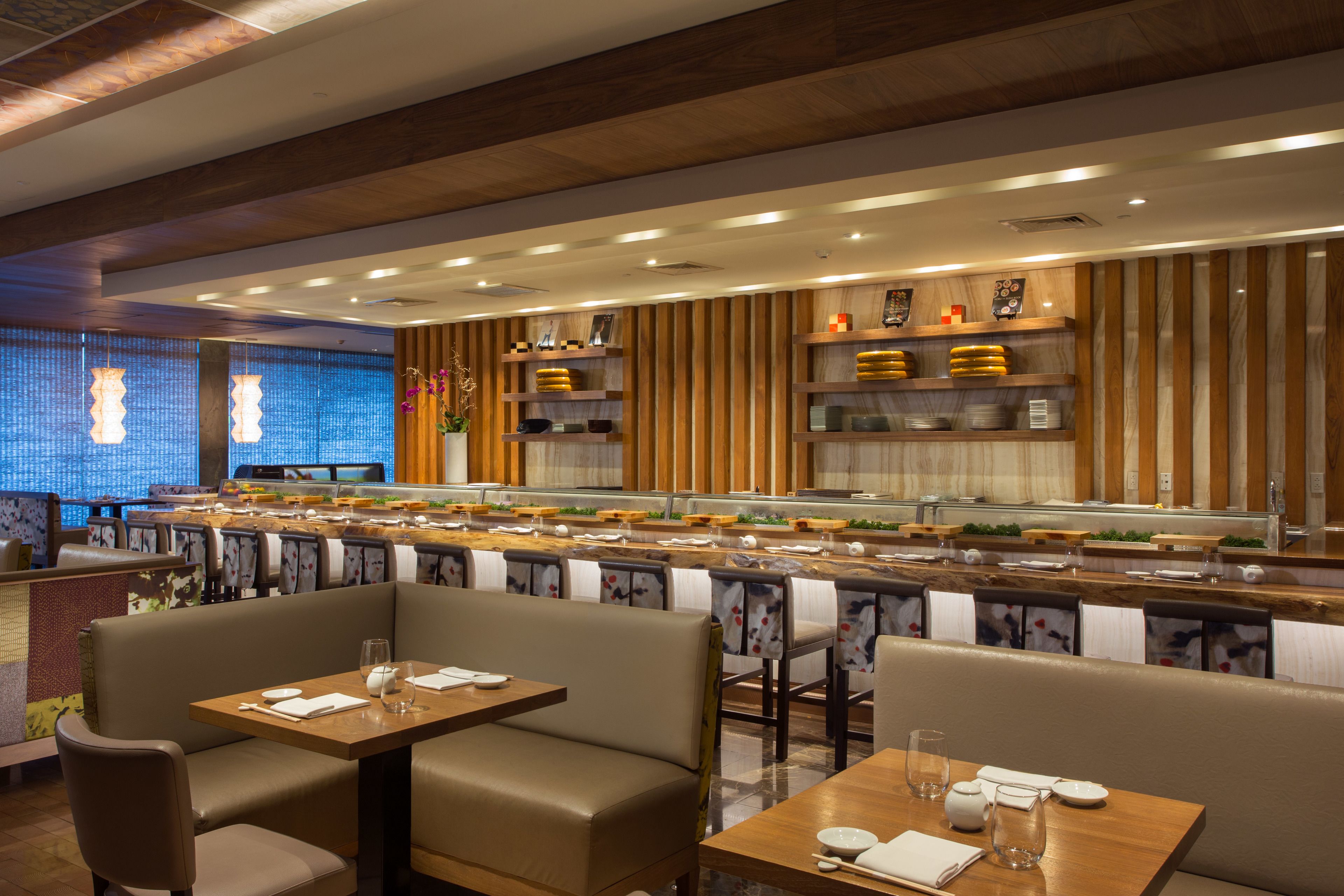 Een restaurant met zitjes en tafels, een buffet en houten lambrisering.