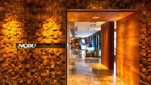 Um hall de hotel moderno com design de parede em madeira e piso de mármore polido.
