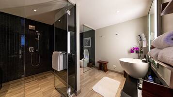 A modern bathroom with a glass-enclosed shower, a large white sink, and a wooden vanity.