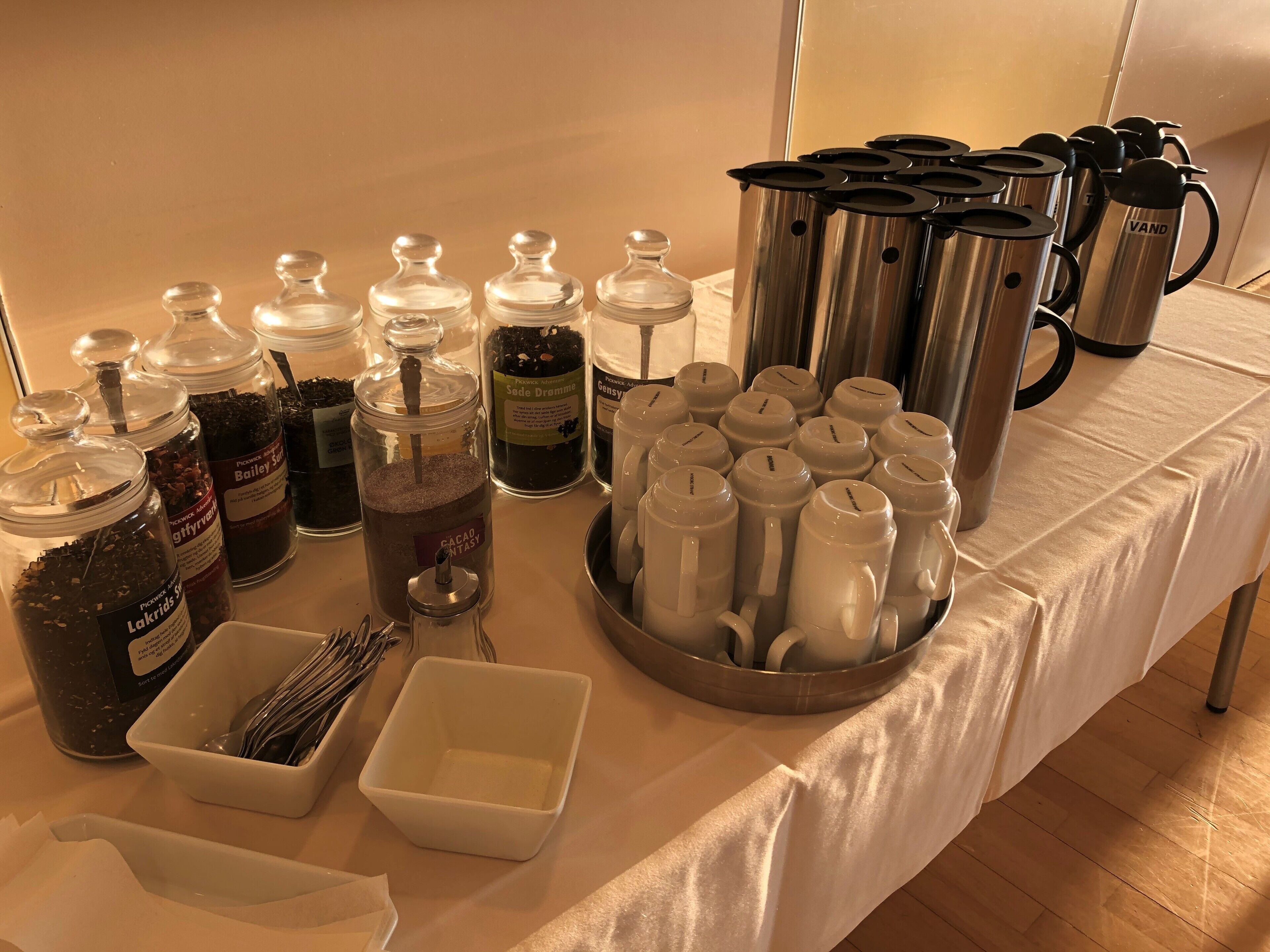 A buffet table with various food items and utensils.