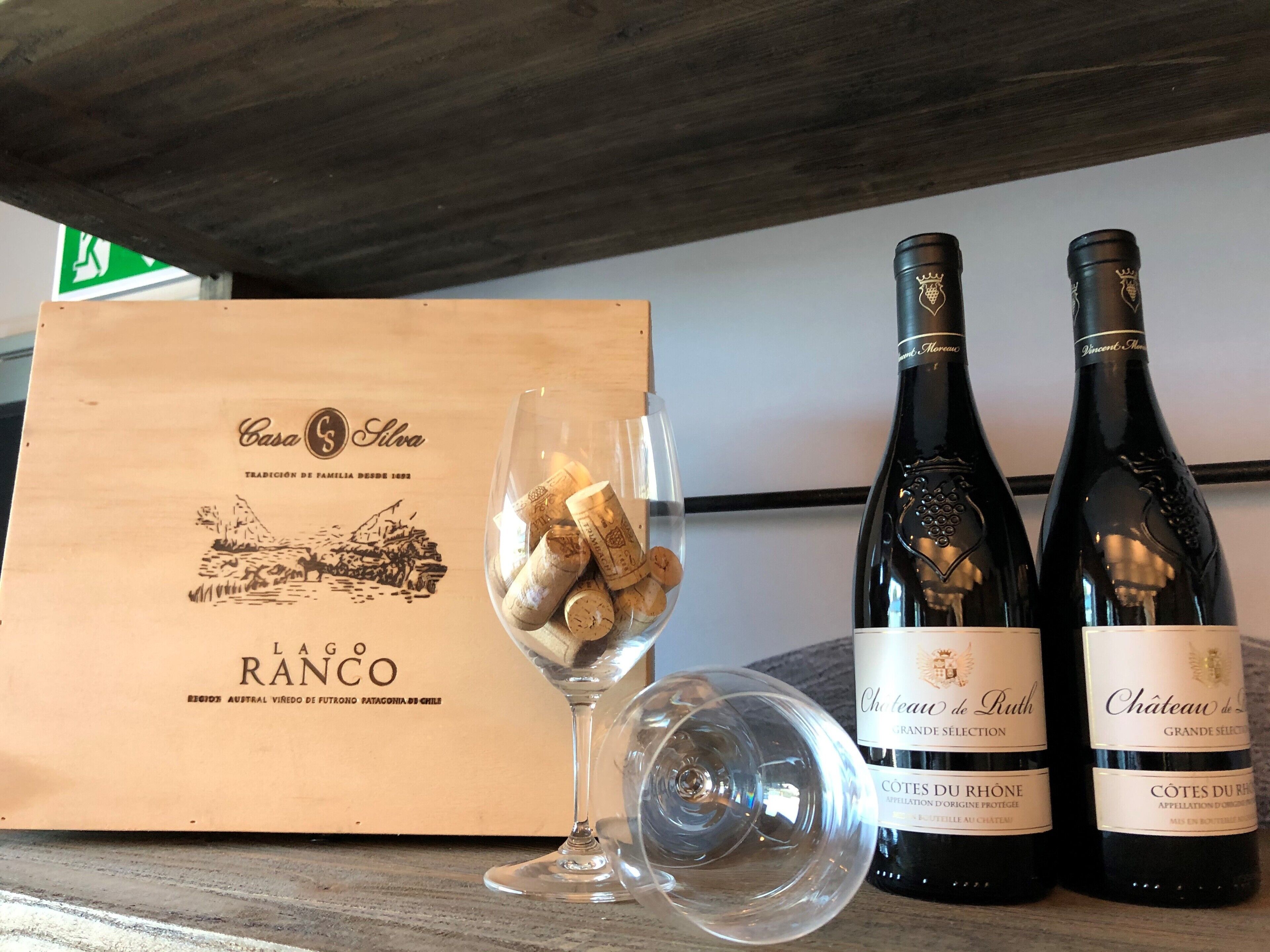 Una caja de madera con la etiqueta "Casa de Silva" y dos botellas de vino con etiquetas "Château de Ruth" y "Château de".
