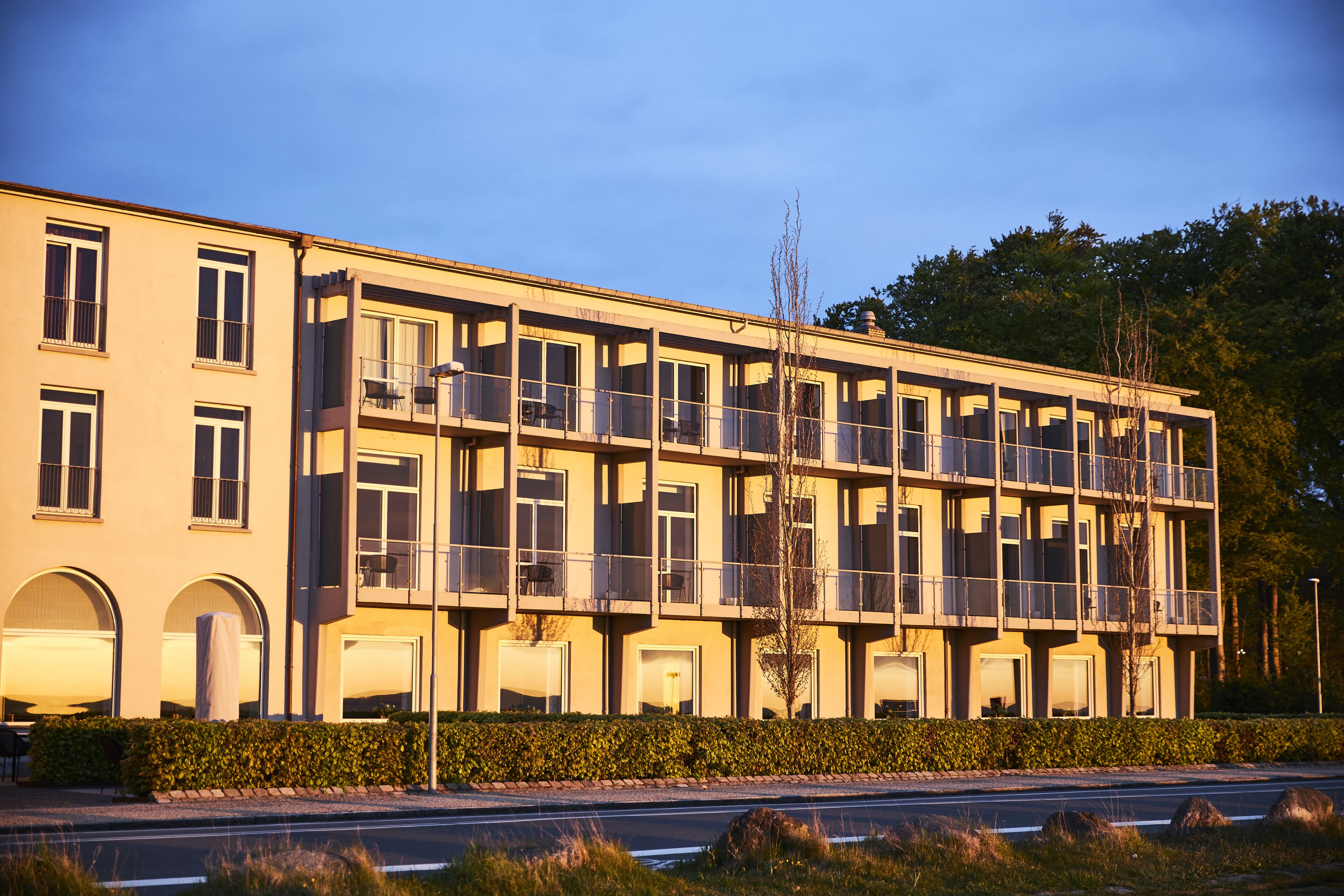 A multi-story hotel with balconies, large windows, and a flat roof.