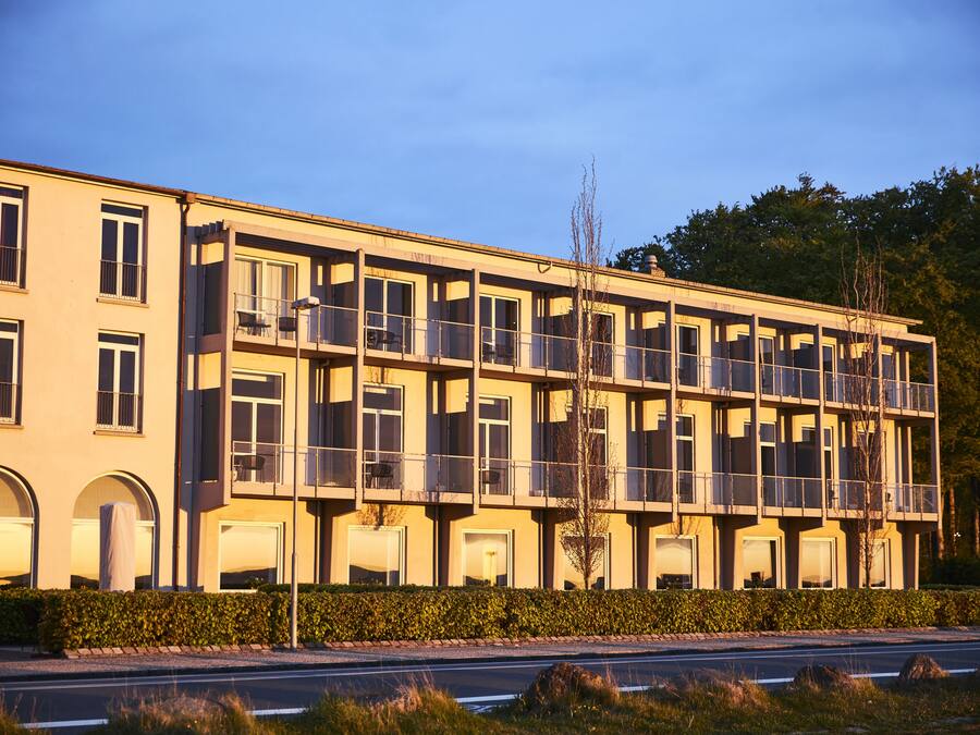 A multi-story hotel with balconies, large windows, and a flat roof.