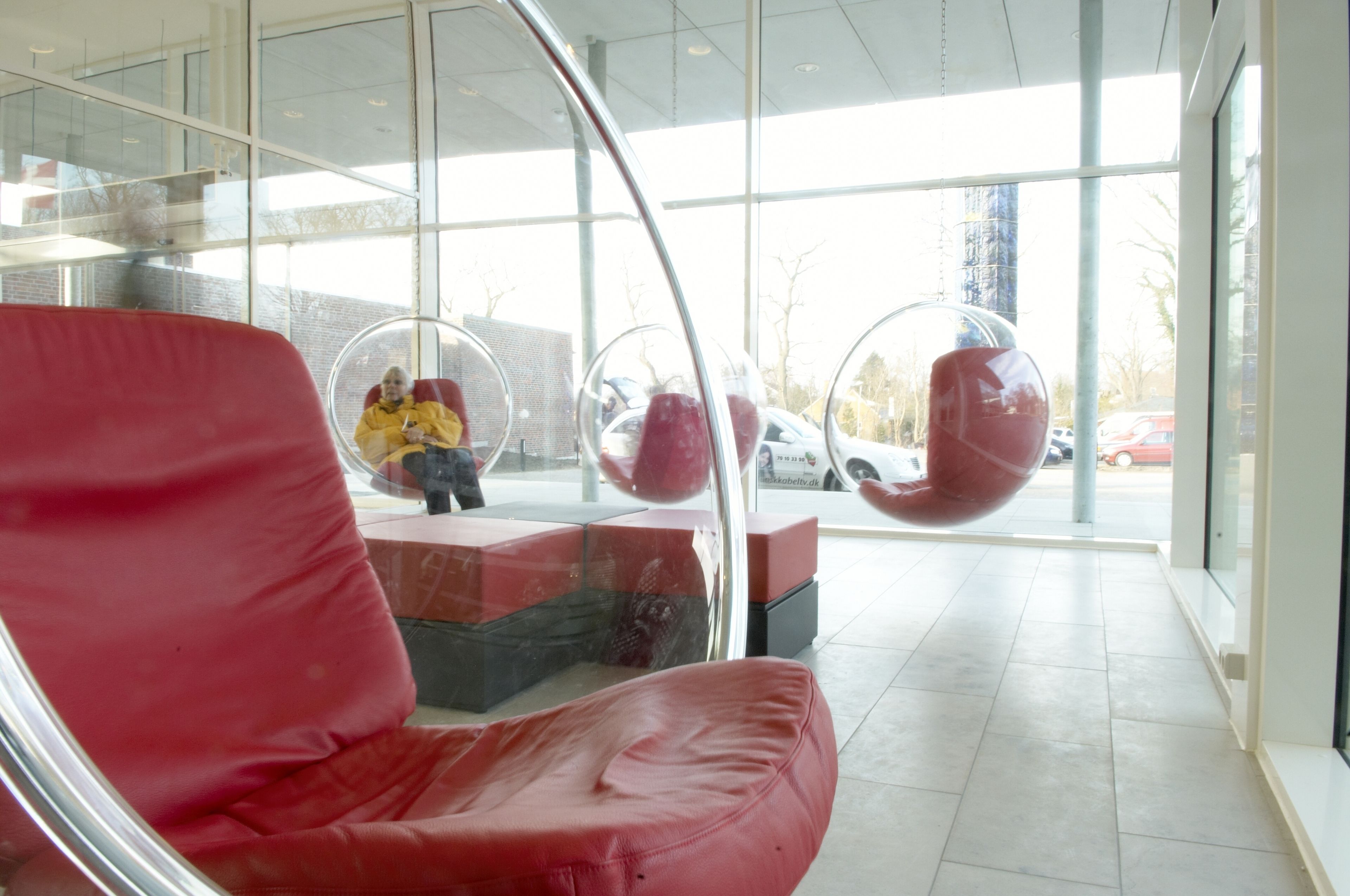 A modern interior with red seating and large windows.