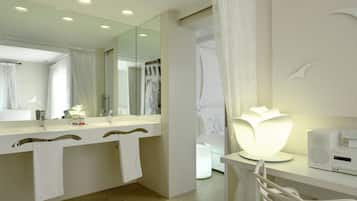 Une salle de bain moderne avec un grand miroir, deux vasques, un plan de toilette blanc et un espace douche.