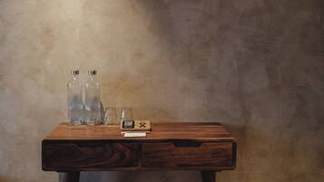 Una mesa de madera con tres botellas transparentes y un código QR.
