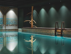 A swimming pool with a tiled edge and a wooden structure in the center.