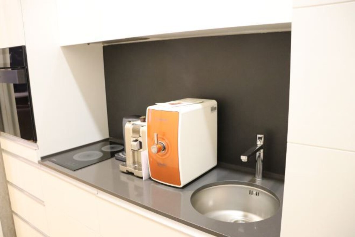 Eine Küchenzeile mit Toaster, Spüle und Herd.