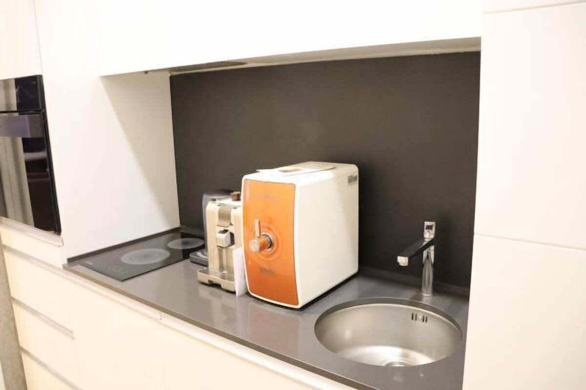 Une petite cuisine équipée d’un grille-pain, d’un évier et d’une cuisinière.