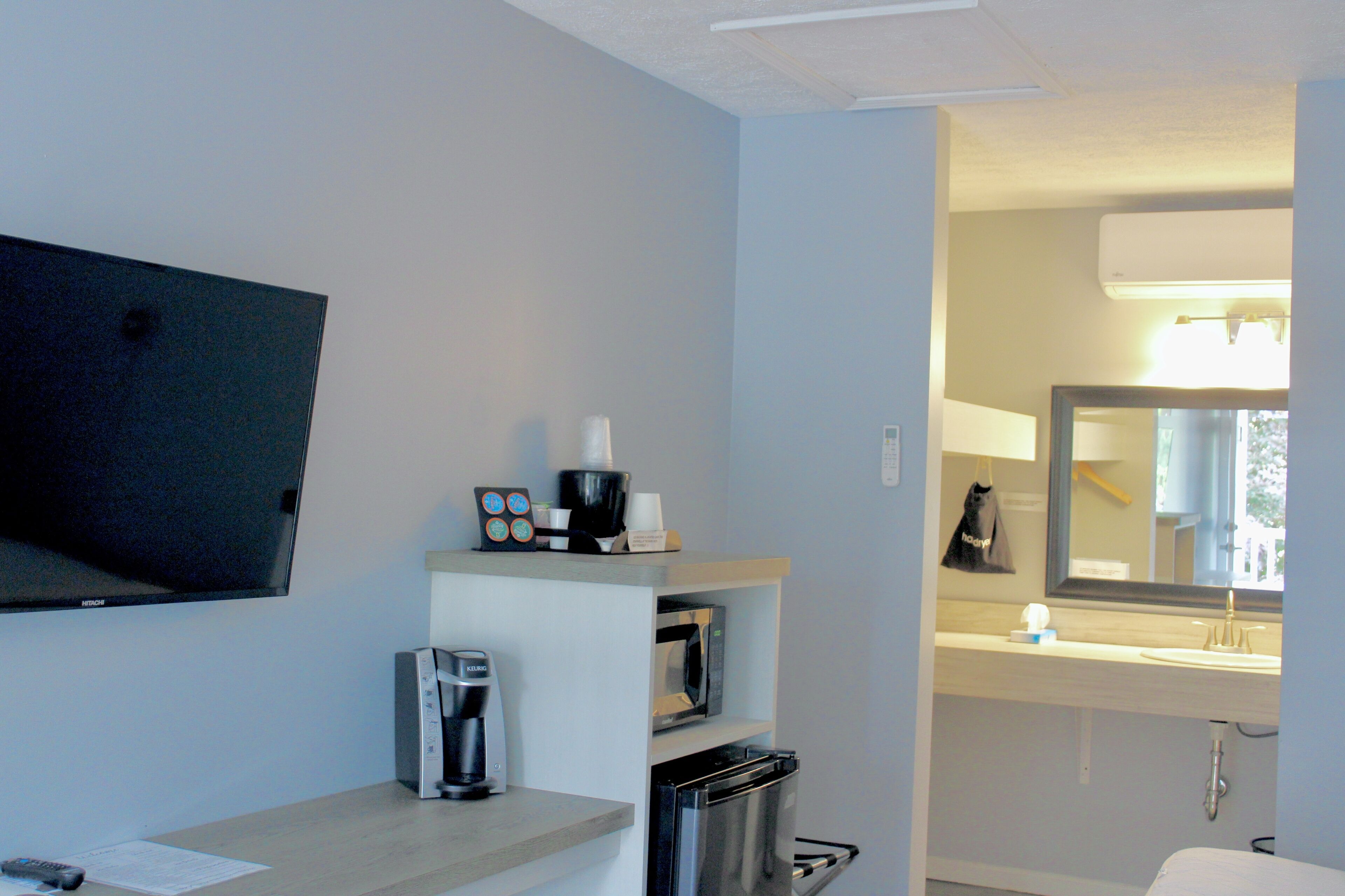 Une chambre d’hôtel équipée d’une télévision à écran plat, d’une machine à café, d’un four à micro-ondes et d’un mini-réfrigérateur.