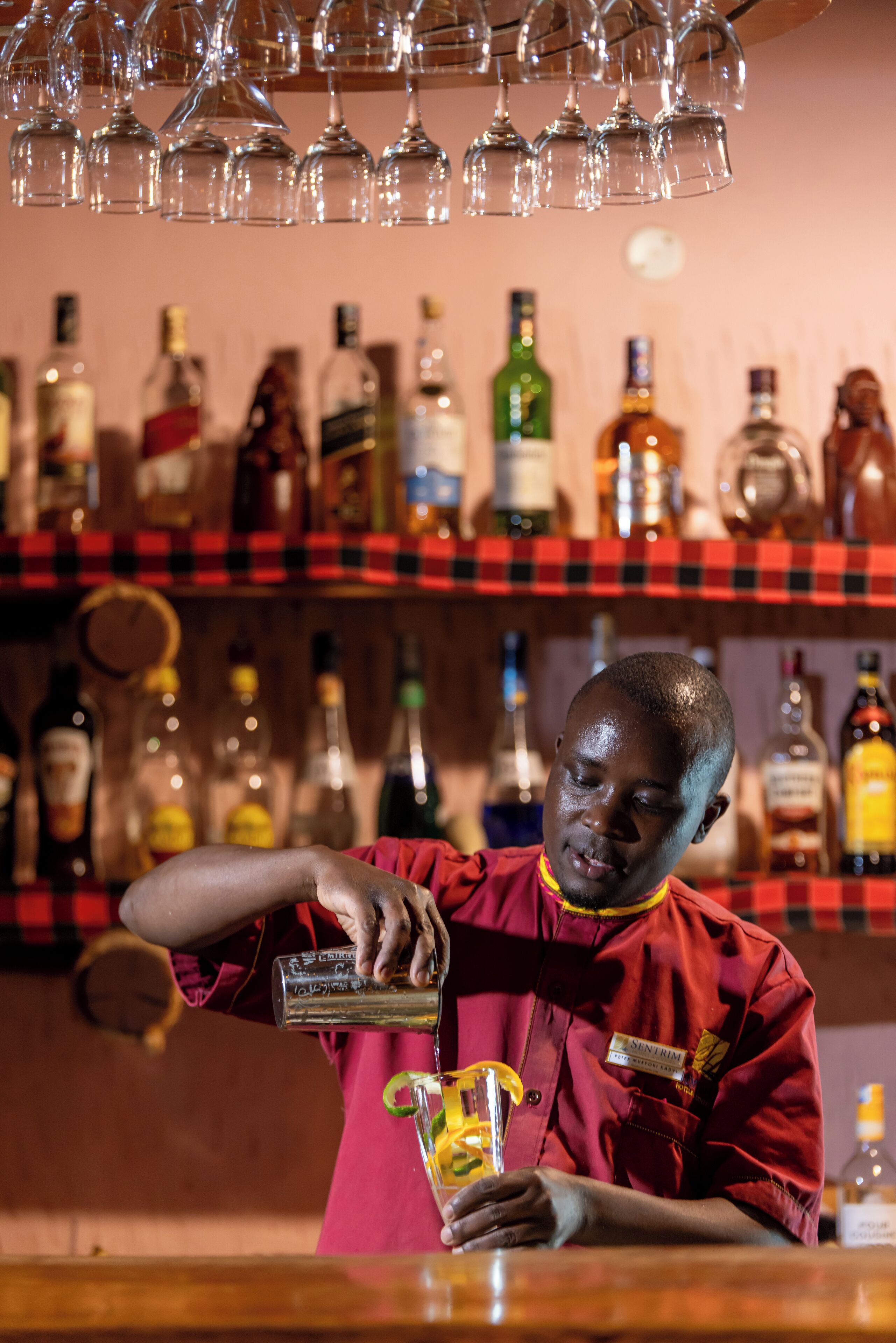 A bartender pouring a drink into a glass.