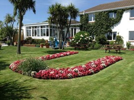 Un jardín bien cuidado con parterres de flores y una mesa de picnic.