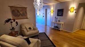 Ein modernes Wohnzimmer mit einer Kronleuchter, einem Sofa, einem Beistelltisch und einem Teppich.