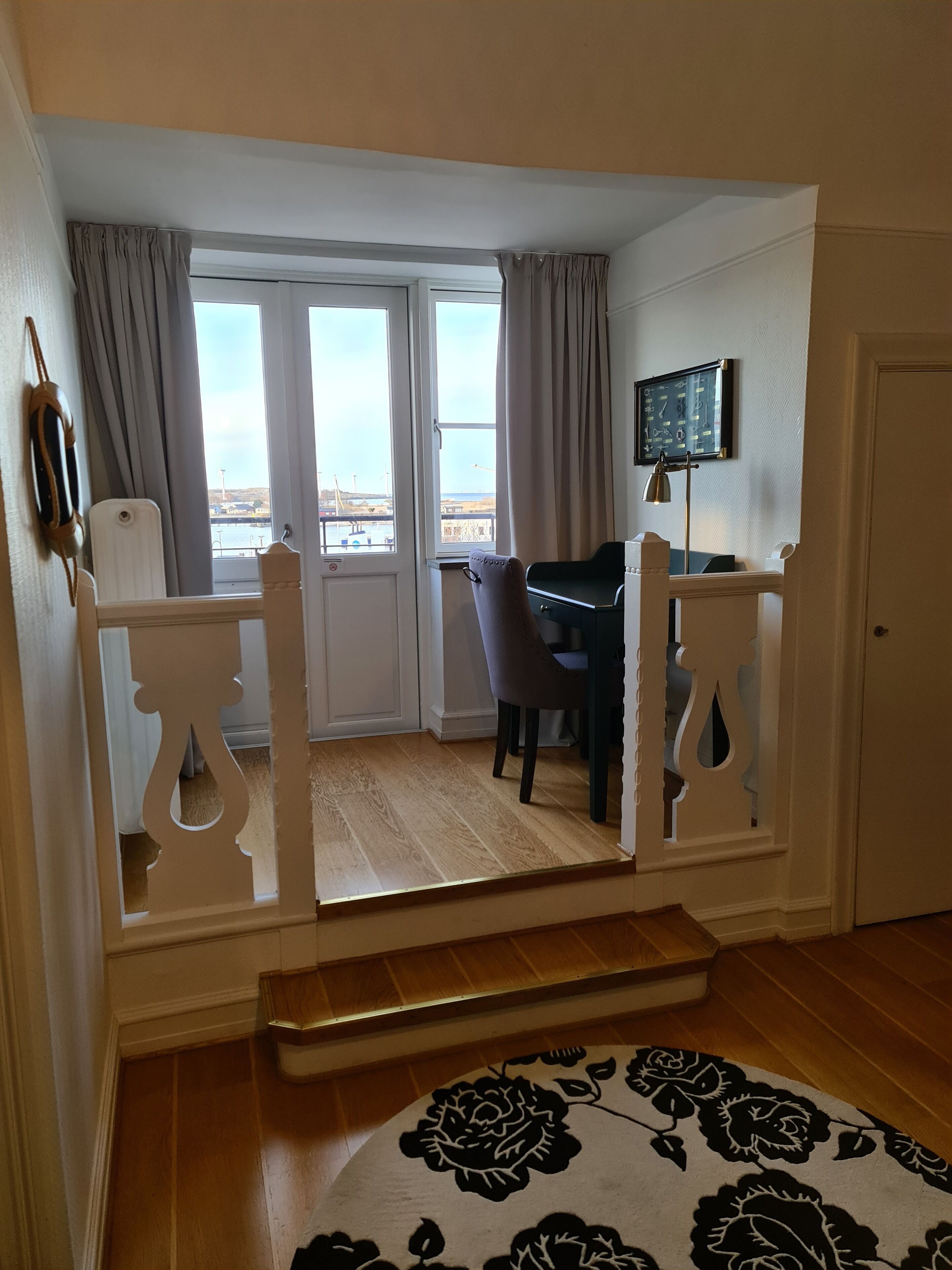 Ein Zimmer mit Schreibtisch, Stuhl und Blick ins Freie.