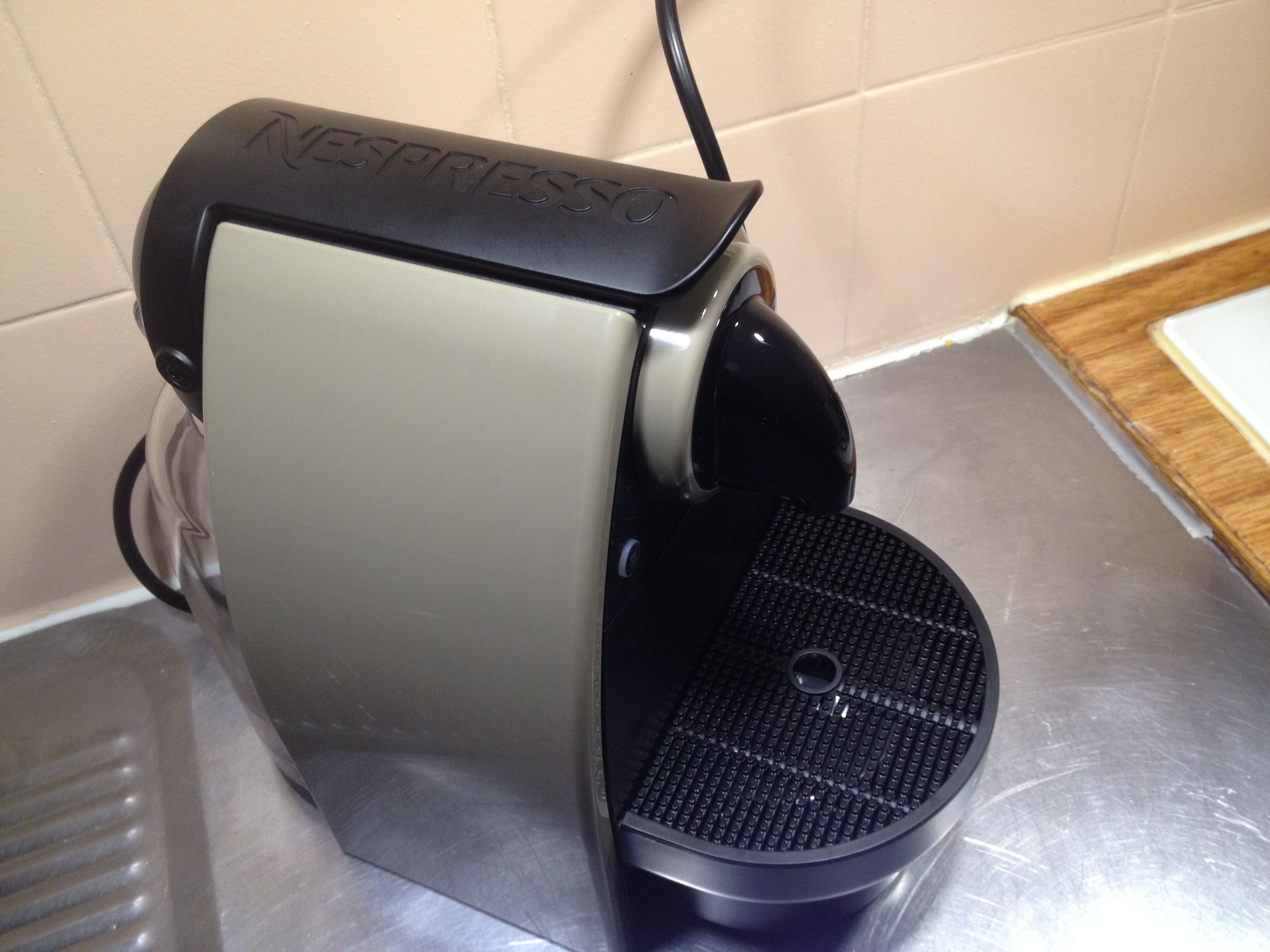A Nespresso coffee machine on a stainless steel countertop.