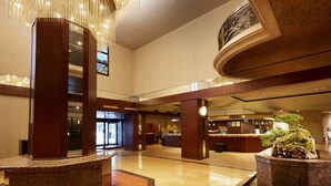 A spacious lobby with a central reception desk, a large chandelier, and a decorative rock garden. - Nishitetsu Grand Hotel (Fukuoka)