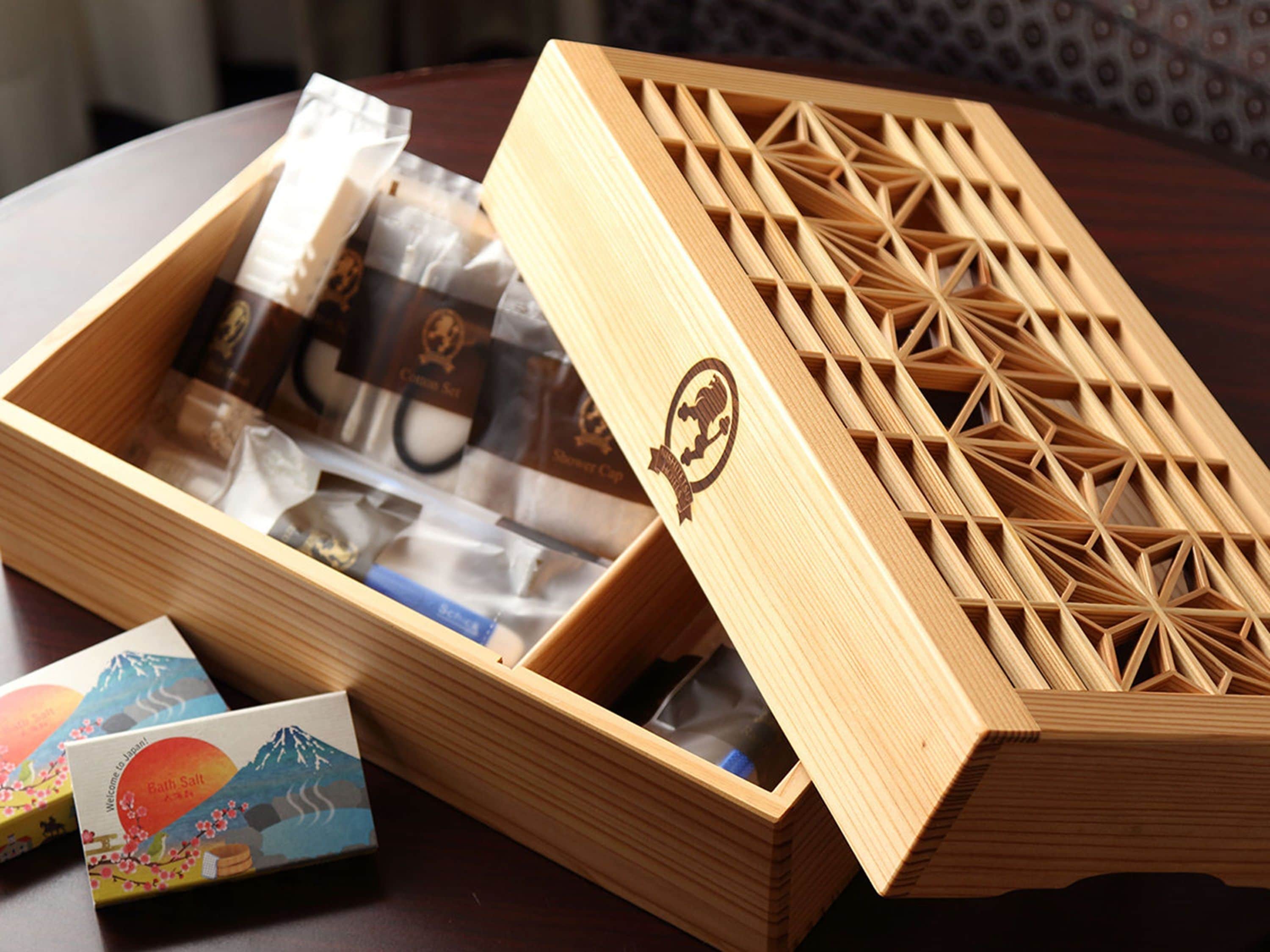 Una caja de madera con un diseño geométrico, ligeramente abierta, mostrando objetos en su interior.