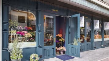 A storefront with a blue facade, large windows displaying flowers, and a sign reading "GIVENY".